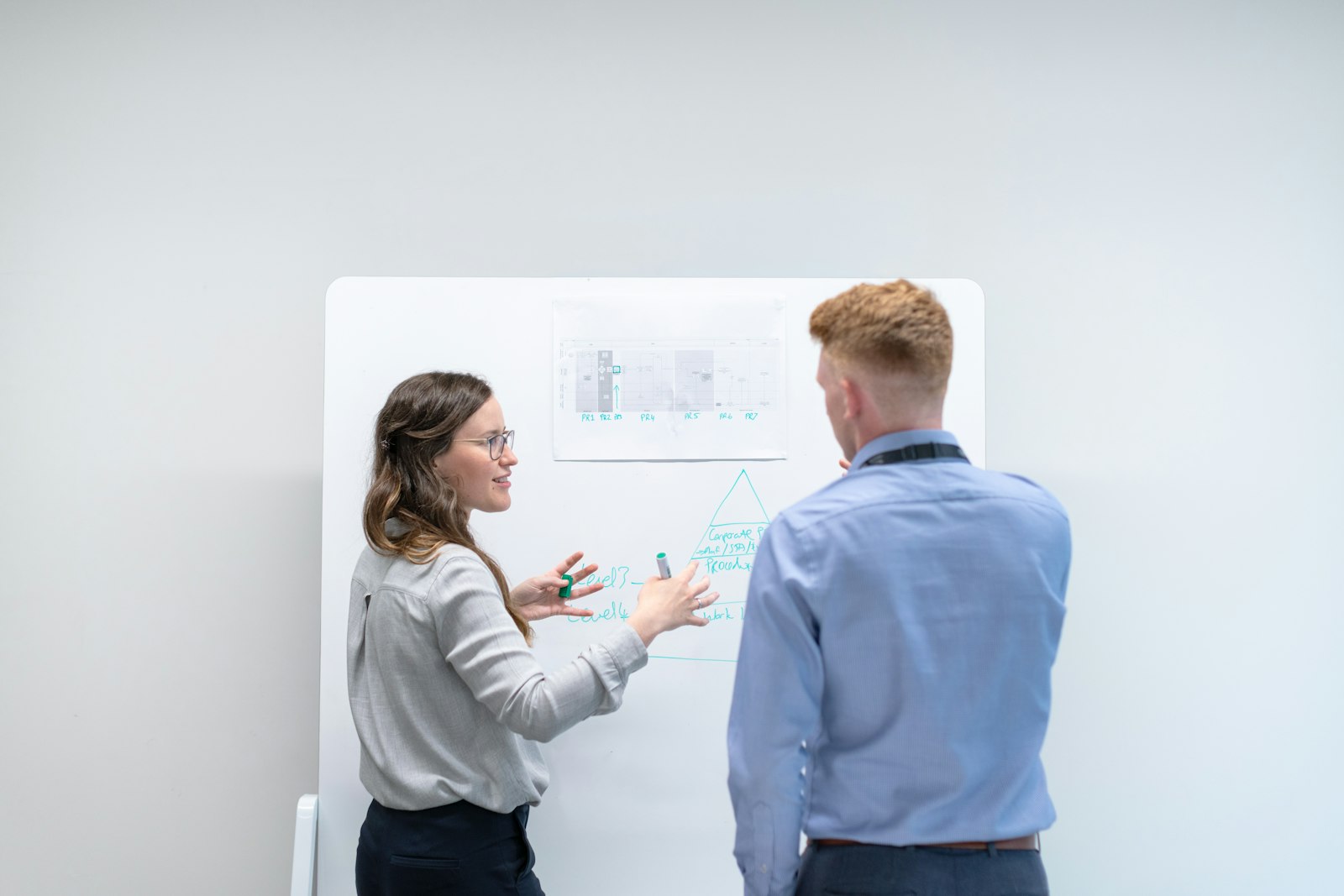 Two engineers discussing a design at a whiteboard